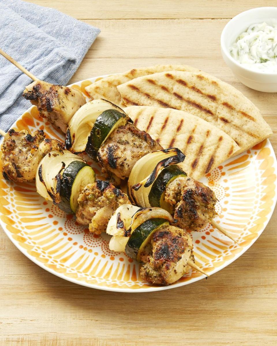 greek chicken kebabs with pita wedges on plate