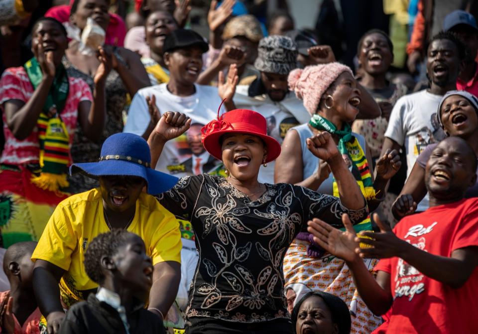 Members of the public sing as they gather in the stands for the funeral service (AP)