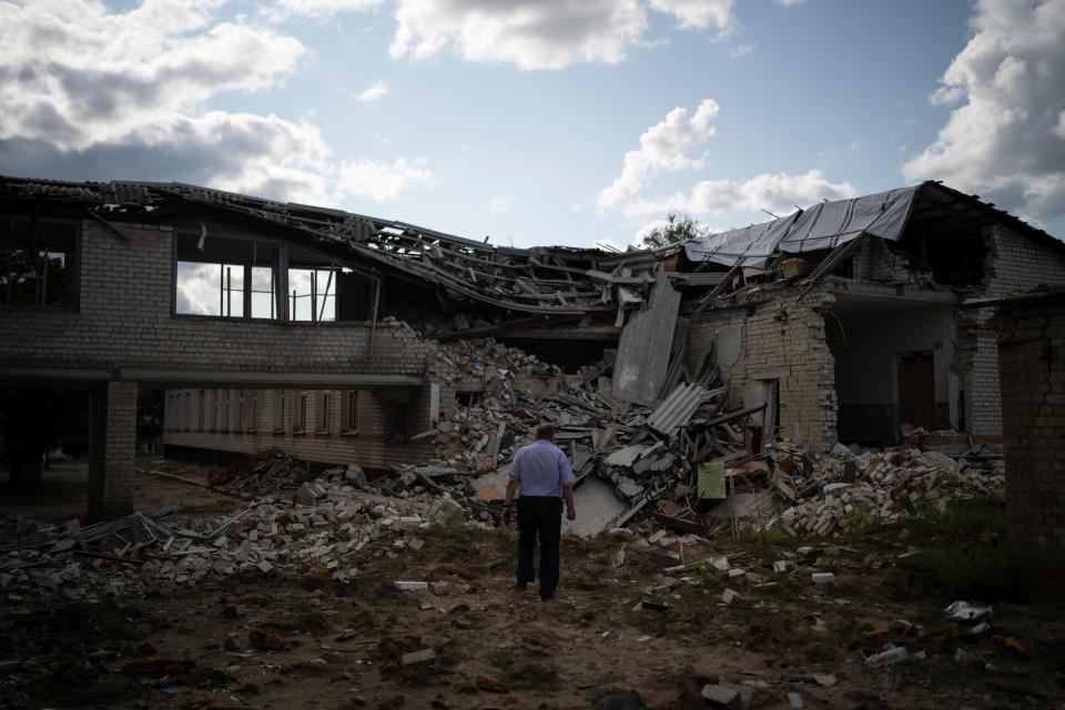 Oleksandr Pishchyk, a school director, stands in front of the school library that was destroyed by shelling in Kupiansk, Ukraine, 23 August 2023 (AP)