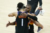 Phoenix Suns' Devin Booker (1) and Chris Paul (3) hug after Game 1 of basketball's NBA Finals against the Milwaukee Bucks, Tuesday, July 6, 2021, in Phoenix. The Suns defeated the Bucks 118-105. (AP Photo/Ross D. Franklin)