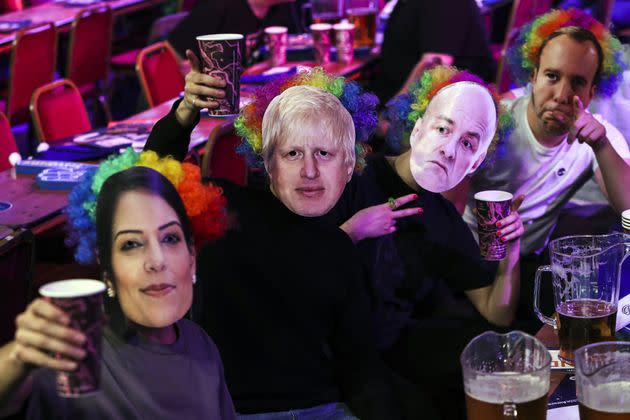 <strong>Spectators wear masks that show the faces of Priti Patel, Boris Johnson, Dominic Cummings and Matt Hancock last week.</strong> (Photo: Kieran Cleeves - PA Images via Getty Images)