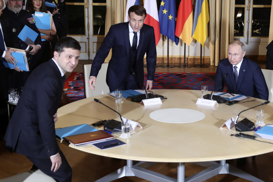 French President Emmanuel Macron, center, Russian President Vladimir Putin, right, and Ukrainian President Volodymyr Zelenskiy, left, sit before a working session with German Chancellor Angela Merkel at the Elysee Palace Monday, Dec. 9, 2019 in Paris. Russian President Vladimir Putin and Ukraine's president are meeting for the first time at a summit in Paris to find a way to end the five years of fighting in eastern Ukraine. (AP Photo/Thibault Camus, Pool)