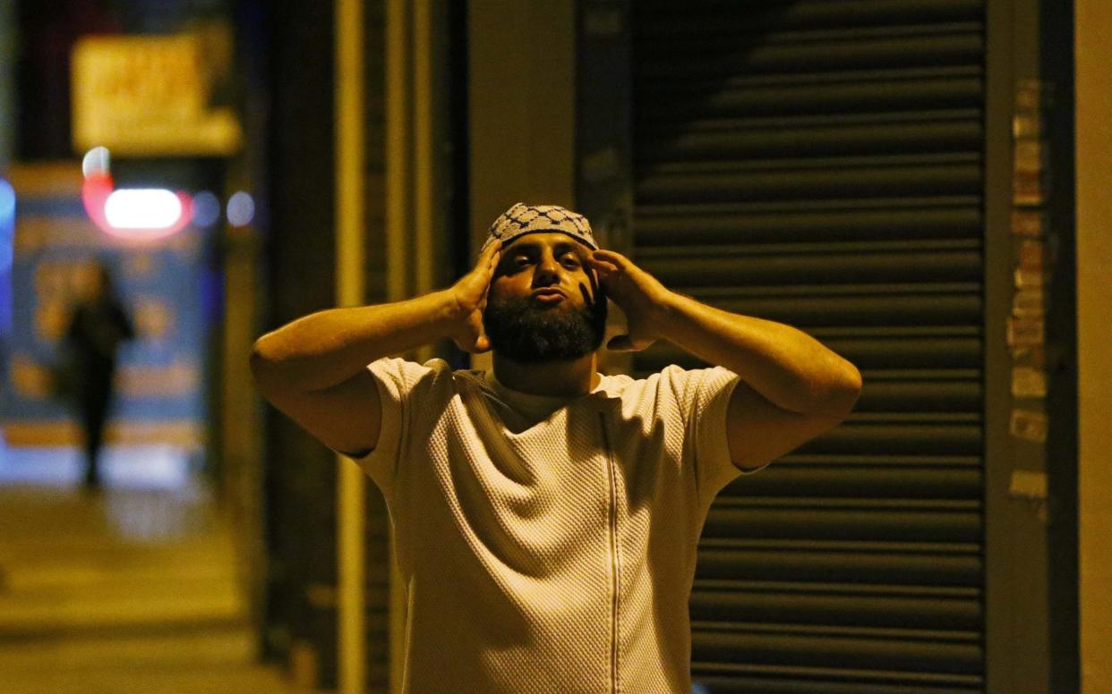 A man prays after a vehicle collided with pedestrians near a mosque in the Finsbury Park neighborhood of North London - REUTERS