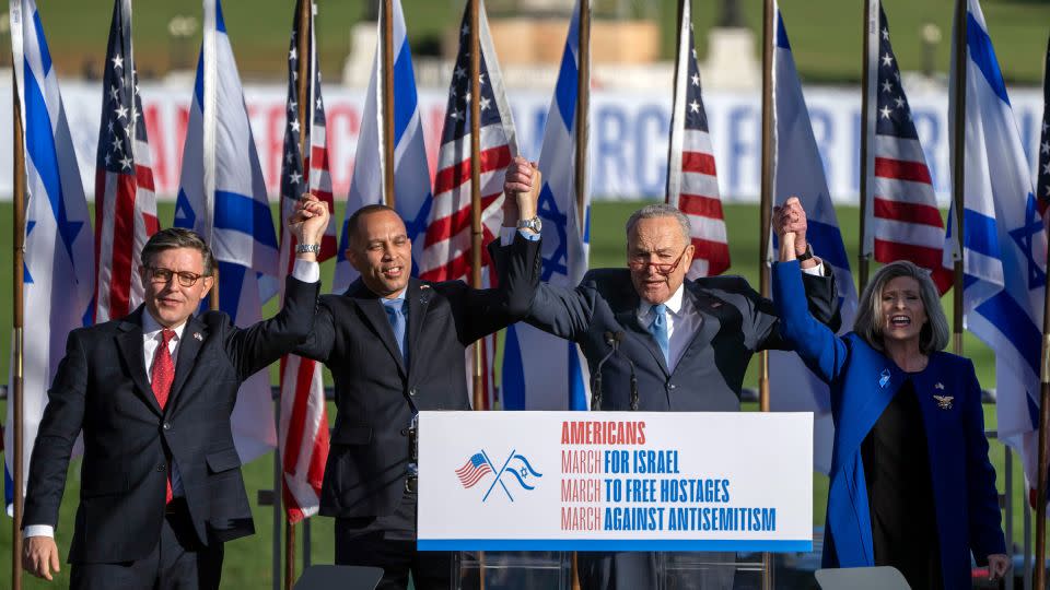 From left, House Speaker Mike Johnson, House Minority Leader Hakeem Jeffries, Senate Majority Leader Chuck Schumer and Sen. Joni Ernst join hands at the March for Israel on Tuesday. - Mark Schiefelbein/AP