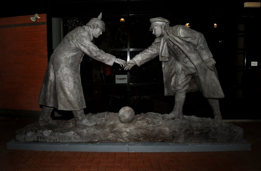 A World War I sculpture features a British and German soldier shaking hands over a soccer ball
