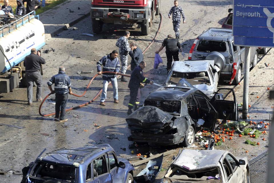 Civil defence members put out a fire at the site of an explosion near the Iranian cultural centre in the southern suburbs of Beirut February 19, 2014. (REUTERS/Mahmoud Kheir)