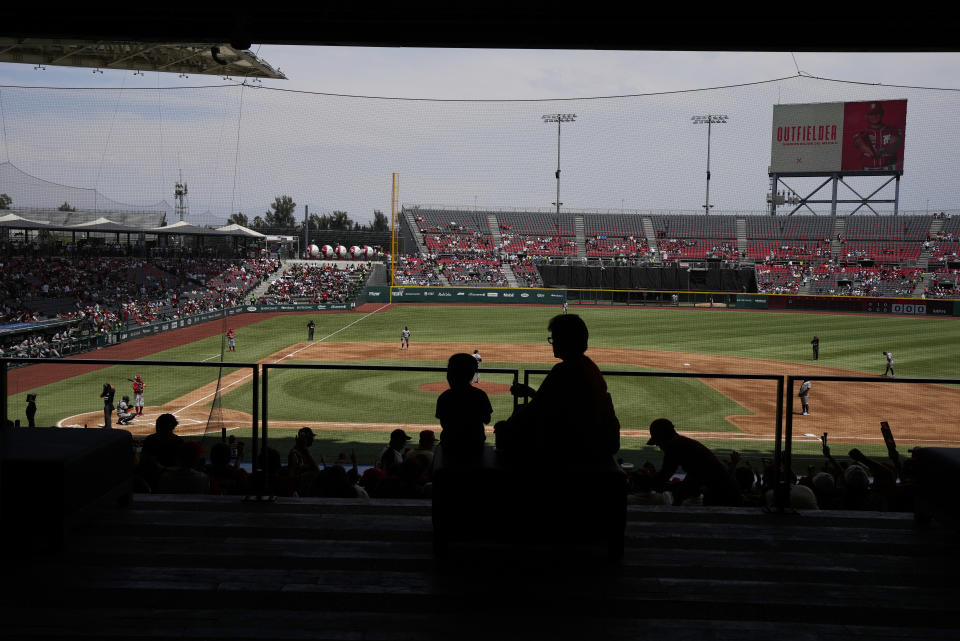 Fanáticos observan el juego entre los Diablos Rojos de México y los Tigres de Quintana Roo por la liga mexicana de béisbol en el estadio Alfredo Harp Helú, el domingo 23 de abril de 2023, en la Ciudad de México. (AP Foto/Fernando Llano)