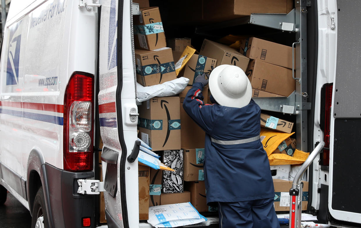 A U.S. Postal Service worker unpacks packages from a truck on December 02, 2019, in San Francisco, California. (Photo by Justin Sullivan/Getty Images)