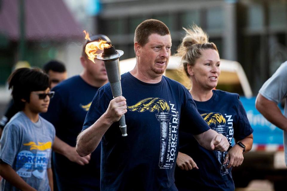 Special Olympics athlete and Merced resident Mark Heffner, 41, carries the torch and “Flame of Hope” during the Law Enforcement Torch Run for Special Olympics Northern California in Merced, Calif., on Thursday, June 15, 2023. Andrew Kuhn/akuhn@mercedsun-star.com
