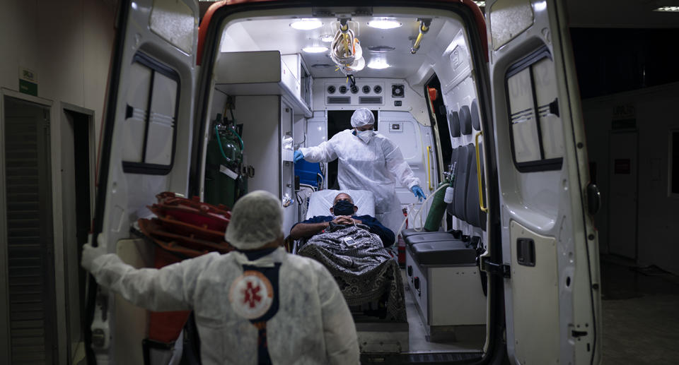 Ambulance staff shows loading a patient into the vehicle.