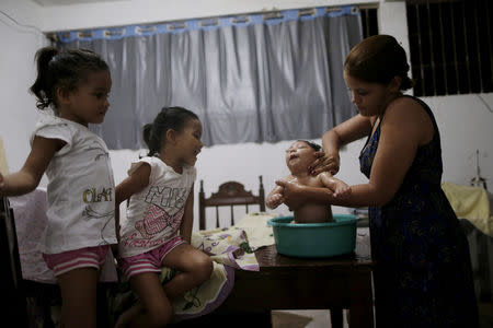 Gabriela Alves de Azevedo bathes her four-month-old daughter Ana Sophia, who was born with microcephaly, at their house in Olinda, Brazil, March 2, 2016. REUTERS/Ueslei Marcelino/File Photo