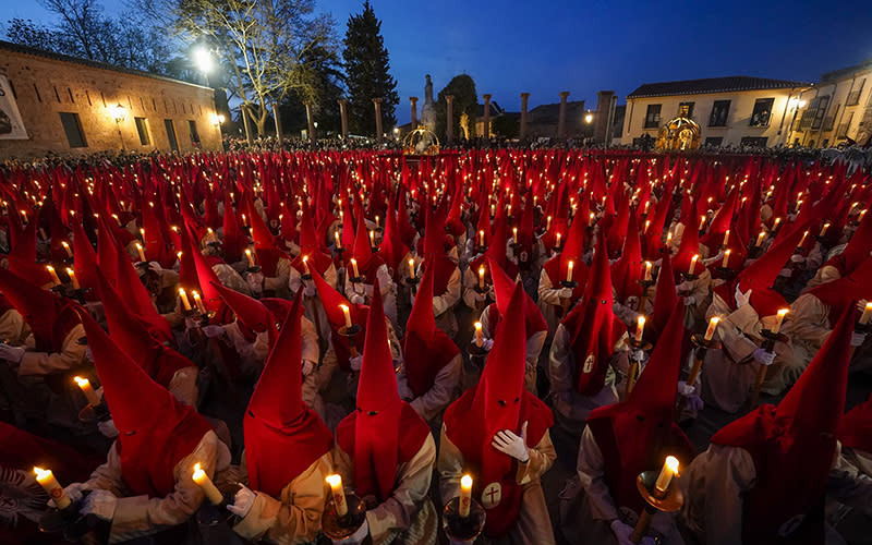 Penitents of the "Santisimo Cristo de las Injurias" brotherhood wear red hoods and take their vows of silence before the start of a procession