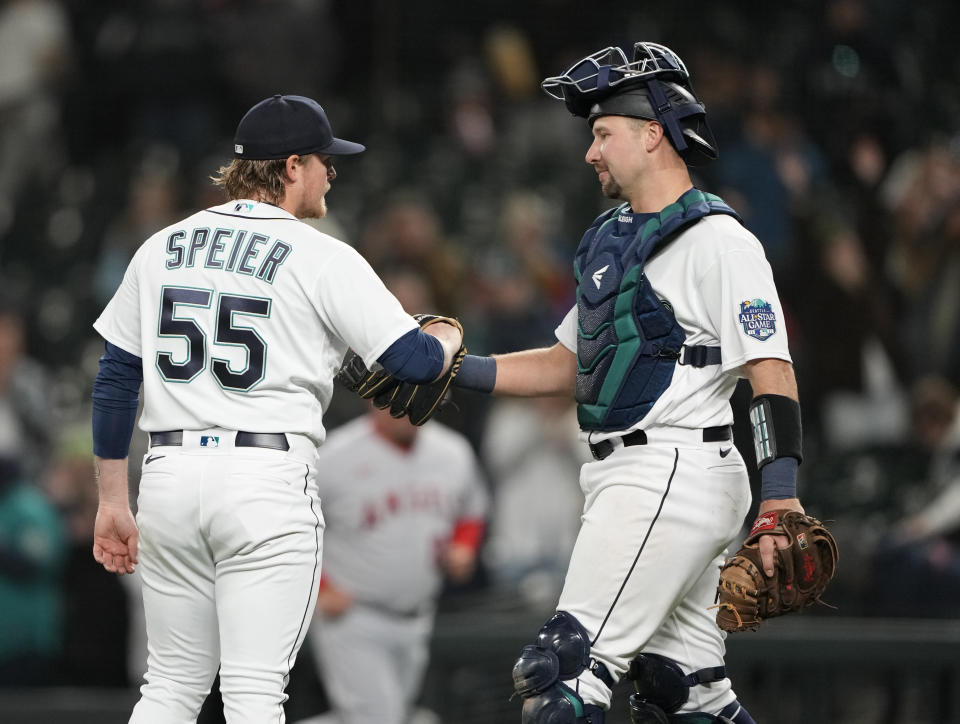 Seattle Mariners relief pitcher Gabe Speier is greeted by catcher Cal Raleigh after the team's 11-2 win over the against the Los Angeles Angels in a baseball game Tuesday, April 4, 2023, in Seattle. (AP Photo/Lindsey Wasson)