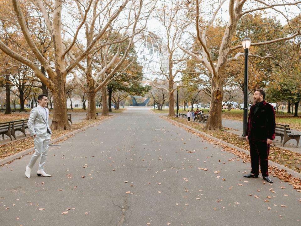 Two grooms look at each other in a park.