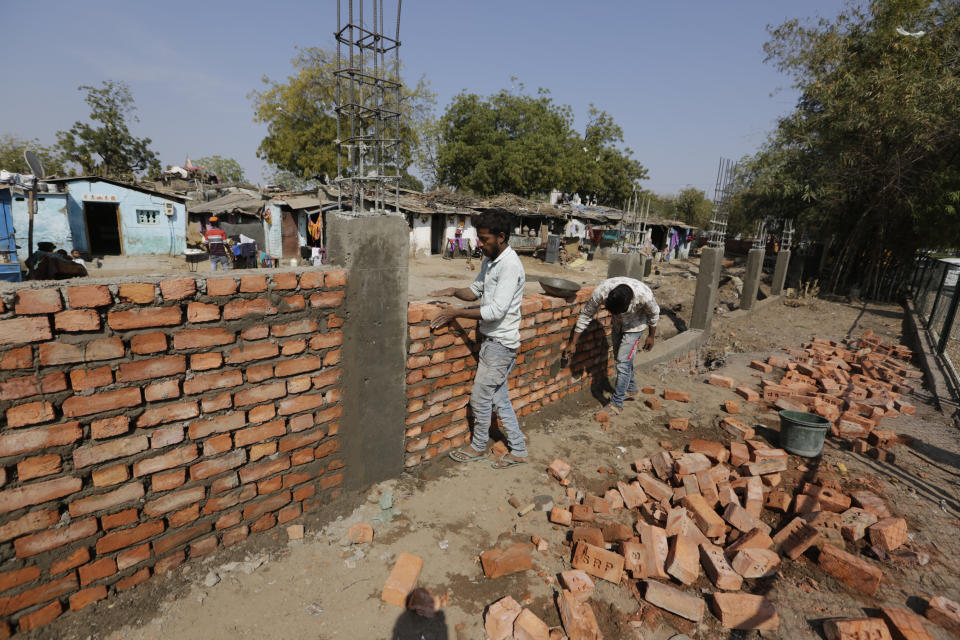 Workers construct a wall in front of a slum ahead of President Donald Trump's visit, in Ahmadabad, India. (Photo: ASSOCIATED PRESS)