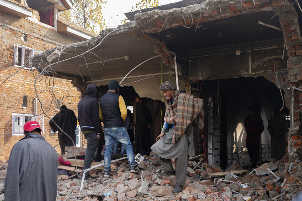 Kashmiri villagers inspect the debris of a damaged residential house where suspected rebels had taken refuge, after a gunfight in Kulgam south of Srinagar, Indian controlled Kashmir, Friday, Nov. 17, 2023. Police in Indian-controlled Kashmir said government forces killed five suspected militants in a gunbattle on Thursday. (AP Photo/Dar Yasin)