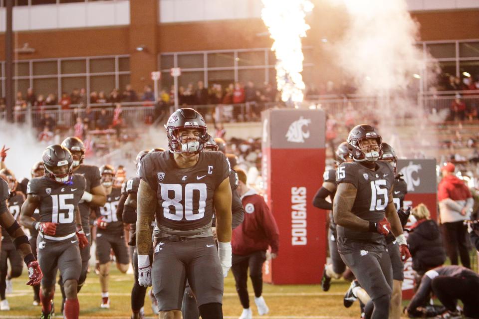 Washington State's Brennan Jackson lead his teammates onto the field before the Cougars' final home game of the season against Colorado. The odds are against WSU in this week's Apple Cup, but Jim Moore is still picking his alma mater to make this a memorable Apple Cup.