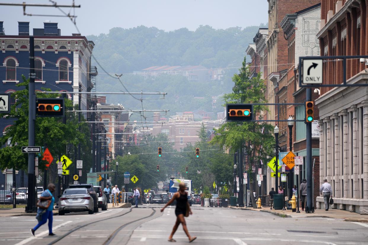 Pedestrians cross Main Street as smoke from Canadian wildfires continues to drift southward into the United States, causing widespread air quality alerts throughout the Midwest, Wednesday, June 28, 2023, in Downtown Cincinnati. 