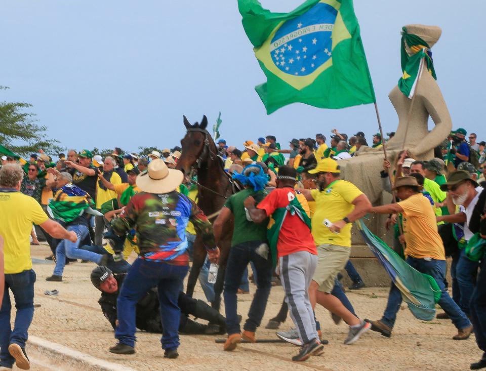 A military police officer falls from his horse during clashes with supporters of Brazil's former President Jair Bolsonaro after an invasion to Planalto Presidential Palace in Brasilia on January 8, 2023. (Sergio Lima/AFP via Getty Images)