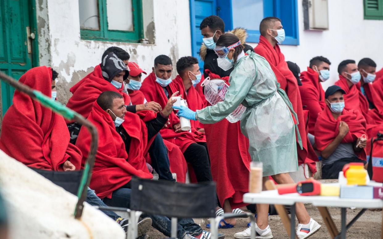 Members of the emergency services assist some 29 migrants with water and food after they arrived on board a toy boat to Caleta de Caballo in Lanzarote - JAVIER FUENTES FIGUEROA/EPA-EFE/Shutterstock /Shutterstock