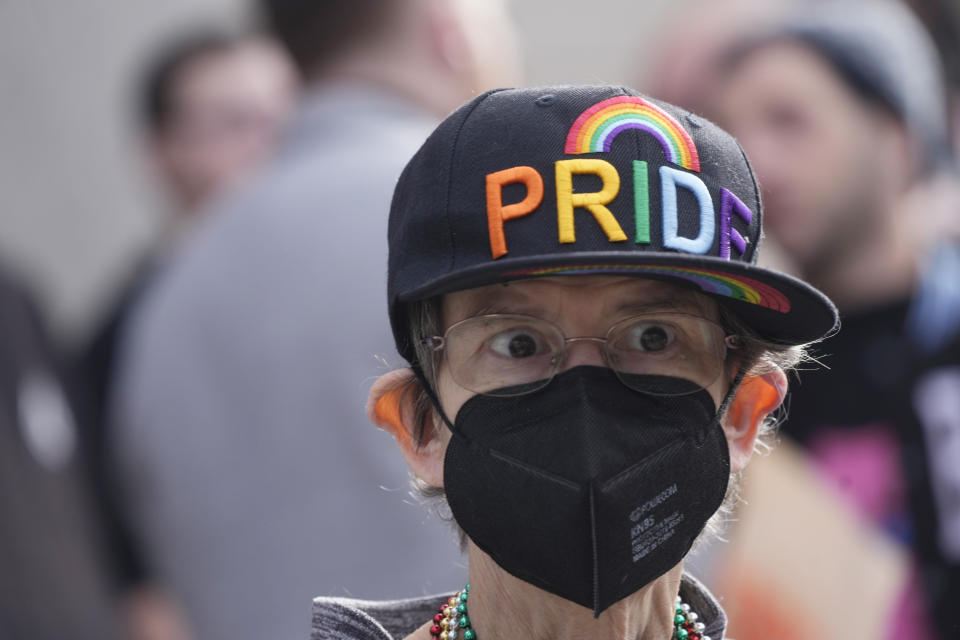 A supporter of Club Q wears a baseball cap after a 25-foot historic pride flag was displayed on the exterior of city hall to mark the weekend mass shooting at a gay nightclub Wednesday, Nov. 23, 2022, in Colorado Springs, Colo. (AP Photo/David Zalubowski)