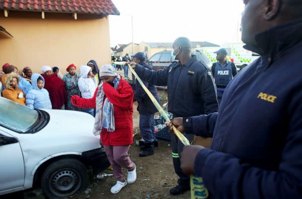 PHOTO: Members of the community and family wait for news outside a township pub where multiple young patrons died in South Africa's southern city of East London, June 26, 2022. (AFP via Getty Images)