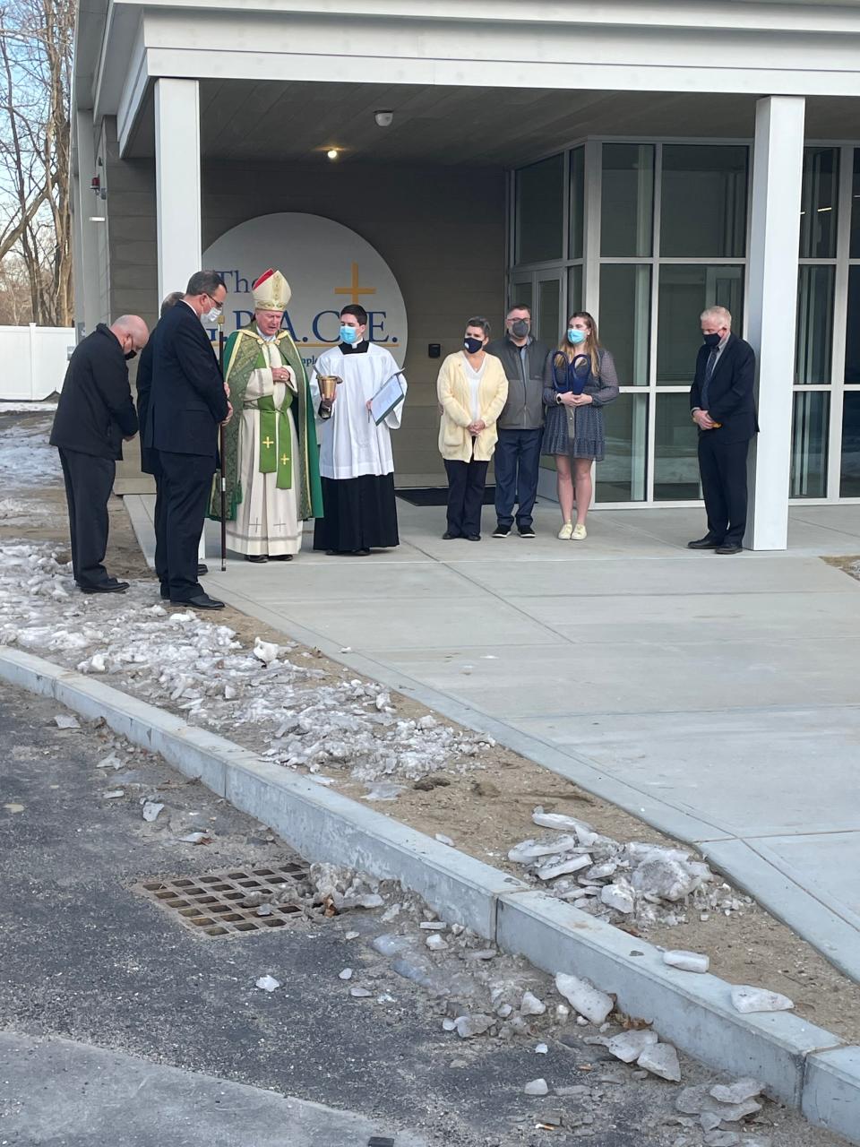 Diocese of Worcester Bishop Robert J. McManus blesses the G.R.A.C.E. Center during a ribbon-cutting ceremony Sunday on the campus of Our Lady of the Valley Regional School in Uxbridge, as the Rett family, right, looks on.