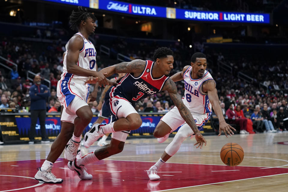 Washington Wizards guard Bradley Beal, center, chases for possession of the ball between Philadelphia 76ers guards Tyrese Maxey, left, and De'Anthony Melton in the first half of an NBA basketball game, Monday, Oct. 31, 2022, in Washington. (AP Photo/Patrick Semansky)