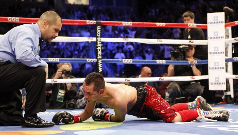 Referee Raul Caiz Jr., left, watches Nonito Donaire on the canvas after Donaire lost to Nicholas Walters in the sixth round during a WBA featherweight title boxing fight, Saturday, Oct. 18, 2014, in Carson, Calif. (AP Photo/Alex Gallardo)