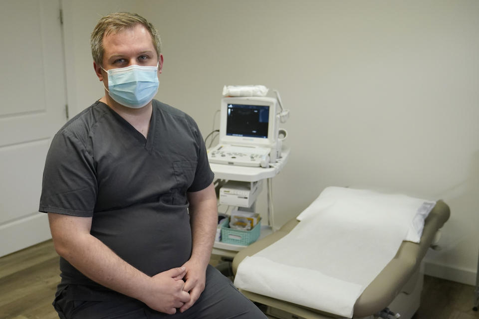 Medical student Ian Peake poses for a photo in an ultrasound room at the Tulsa Women's Clinic, Monday, April 11, 2022, in Tulsa, Okla. Abortion training is not offered at Oklahoma's two medical schools and education on the topic is limited. Students who want to learn typically must seek out doctors providing abortion outside the traditional medical education system. "My first attempt to get any exposure in medical school took about six months to find any provider who was willing to let me shadow," Peake said. (AP Photo/Sue Ogrocki)