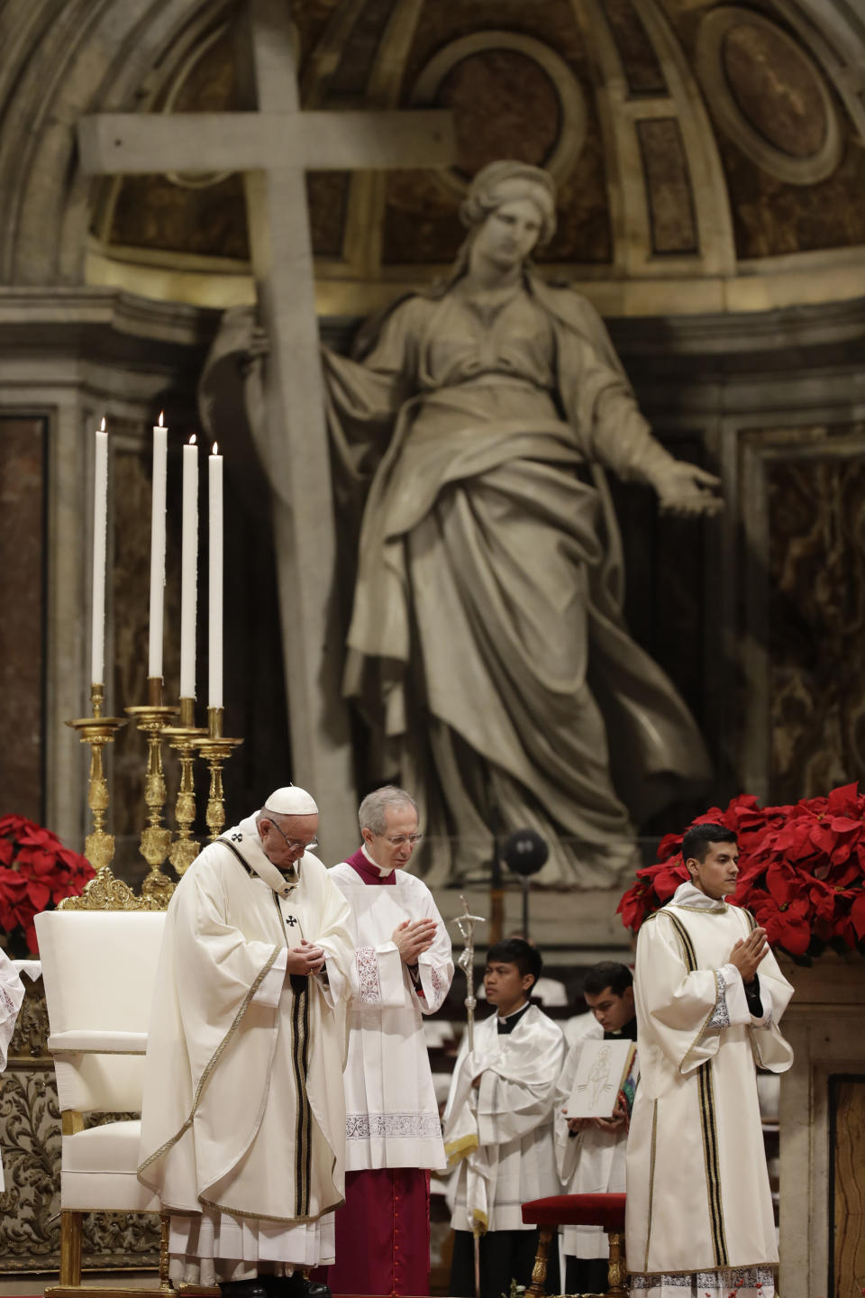 Pope Francis, left, celebrates the Christmas Eve Mass in St. Peter's Basilica at the Vatican, Monday, Dec. 24, 2018. (AP Photo/Alessandra Tarantino)