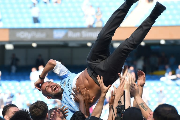 City on top: Jubilant players lift Pep Guardiola in celebration of their Premier League title