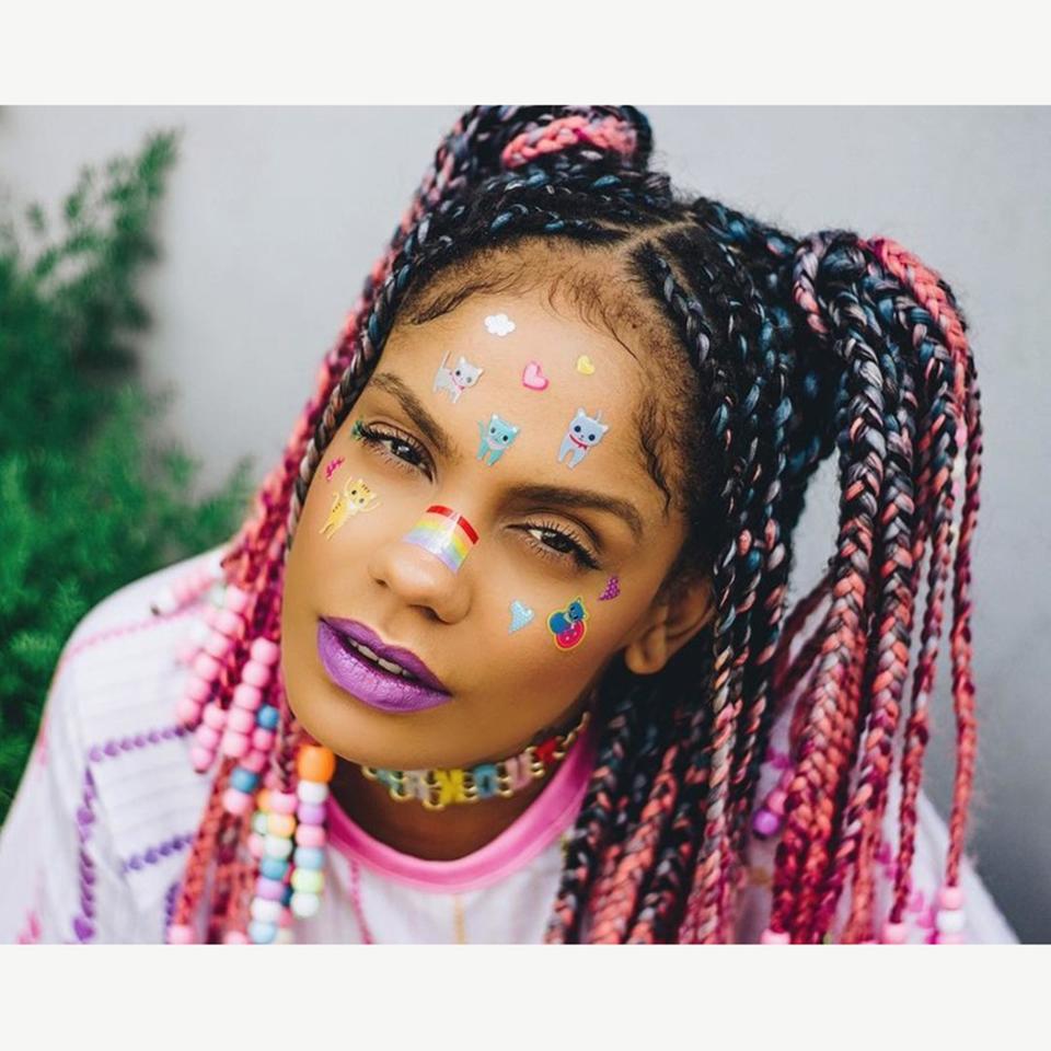 Known for her colorful style, Brazilian blogger <a href="https://www.instagram.com/p/Bhbu9QWjPoS/?hl=en&taken-by=magavilhas" rel="nofollow noopener" target="_blank" data-ylk="slk:Magá Moura;elm:context_link;itc:0;sec:content-canvas" class="link ">Magá Moura</a> looks like she came straight out of the '90s with her face stickers and unicorn braids adorned with pastel beads on the ends. Here, she styled them in high pigtails, leaving some braids out in the front to frame her face.