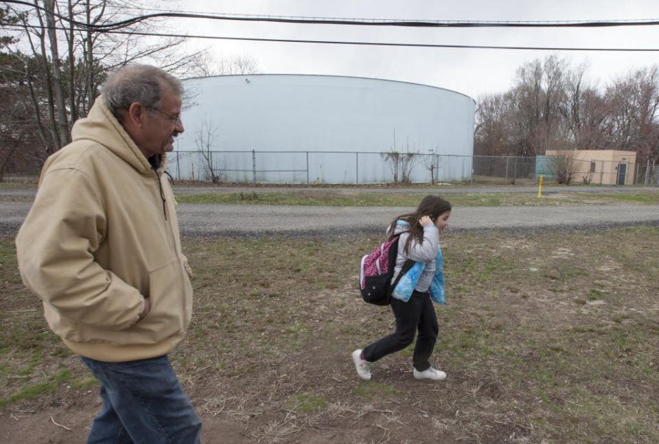 The Fair Lawn well fields that sit in a Superfund site shown in the background as Moreno Siano walks his granddaughter Kayla Stafford, 9, home from school on March 18, 2016.