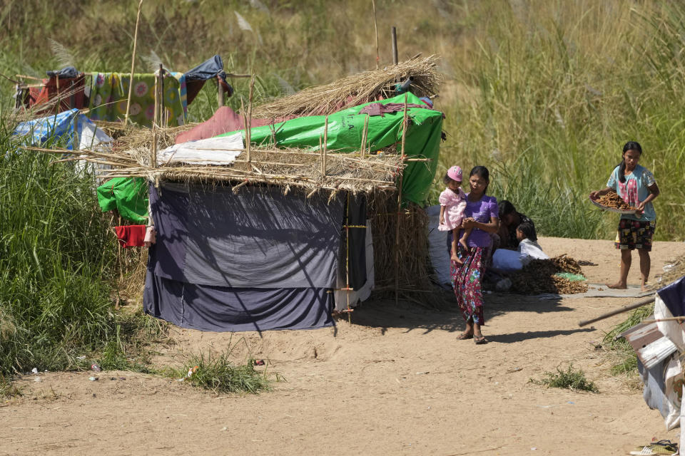 Villagers displaced from their communities due to recent attacks by the Myanmar military sit outside their makeshift dwellings on the banks of the Moei River by the Thailand Myanmar border in Mae Sot, Tak province, northern Thailand, Monday, Jan. 24, 2022. The army takeover in Myanmar a year ago that ousted the elected government of Aung San Suu Kyi brought a shocking end to the effort to restore democratic rule in the Southeast Asian country after decades of military rule. But at least as surprising has been the level of popular resistance to the seizure of power, which has blossomed into an insurgency. (AP Photo/Sakchai Lalit)