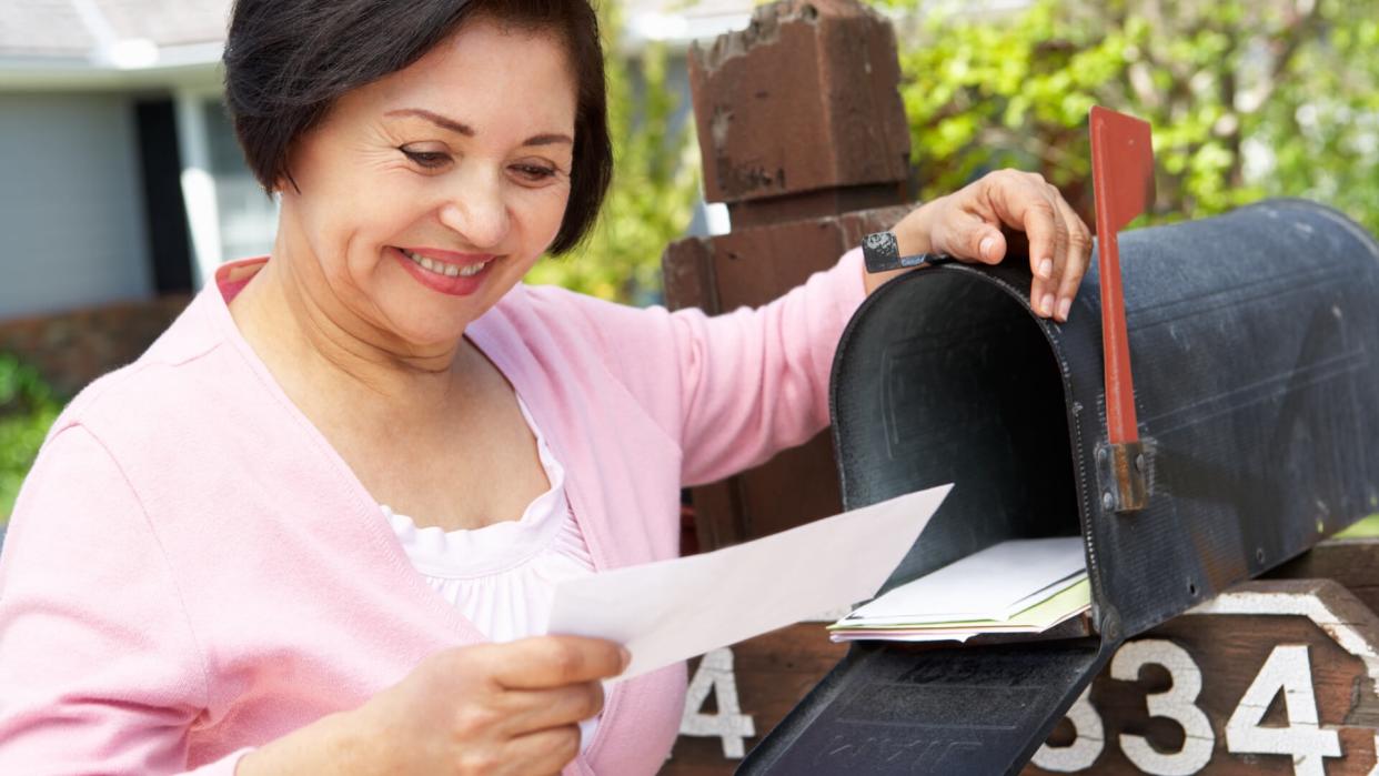Senior woman looking at check received in the mail