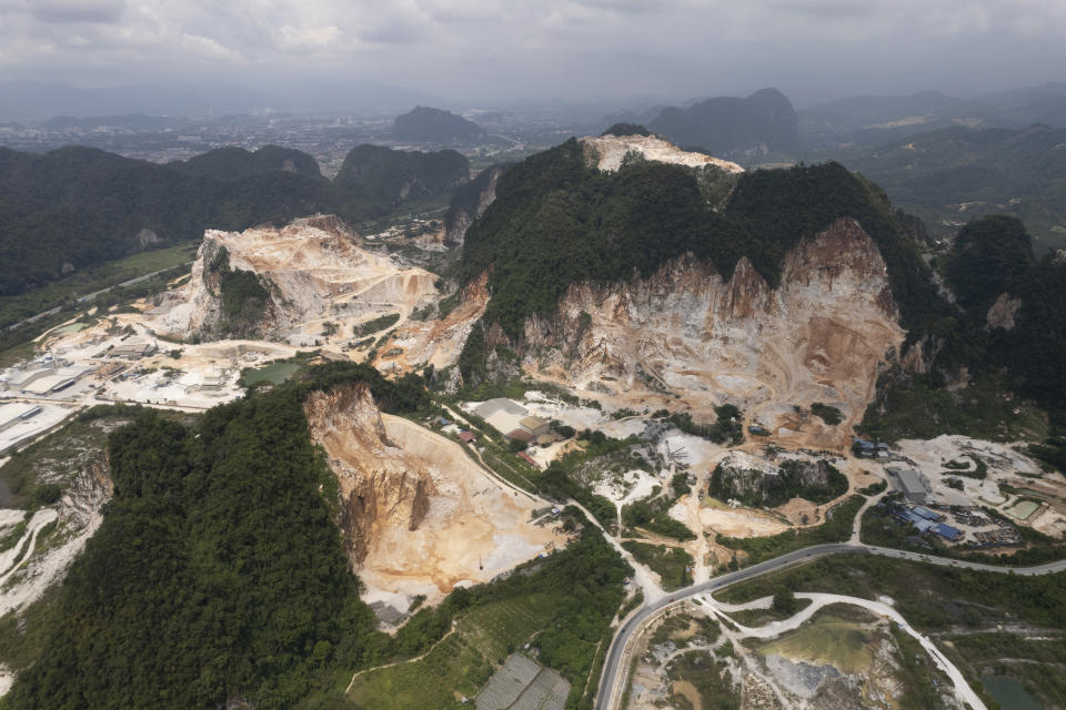 FILE - Deforested mountains from massive limestone quarries are seen in Ipoh, Perak state Malaysia, Nov. 5, 2021. One out of five people in the world depends on wild species for food and income, according to a new UN-backed report. Climate change, pollution and overexploitation, however, have put a million species of plants and animals at risk of extinction. (AP Photo/Vincent Thian, File)