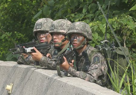 South Korean soldiers take position during a search and arrest operation as troops standoff with a conscript soldier who shot and killed five comrades in Goseong June 23, 2014. REUTERS/Hwang Gwang-mo/Yonhap