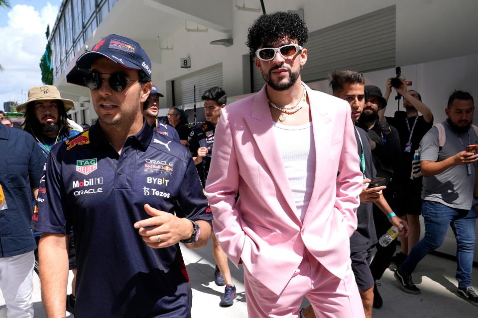 Red Bull driver Sergio Perez, left, walks in the Formula One paddock with Puerto Rican reggaeton musician Bad Bunny on Sunday in Miami.