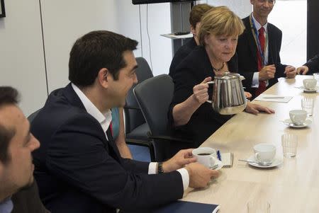 Greek Prime Minister Alexis Tsipras (L) and German Chancellor Angela Merkel (R) attend a meeting with European Commission President Jean-Claude Juncker and French President Francois Hollande (not seen) prior to a euro zone leaders summit in Brussels, Belgium, July 7, 2015. REUTERS/Philippe Wojazer