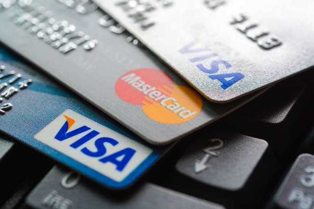 Bangkok, Thailand - Jun 23, 2015 : Group of credit cards on computer keyboard with VISA and MasterCard brand logos