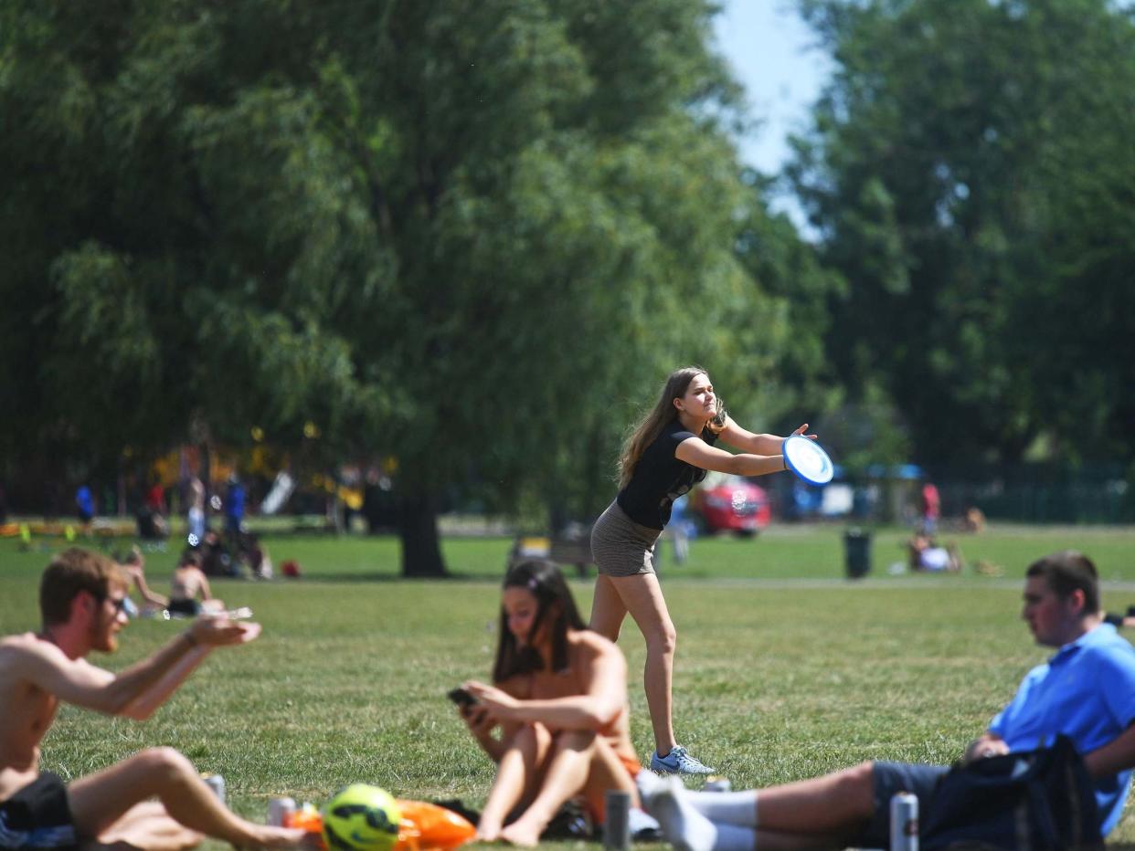 People enjoy the hot weather on Clapham Common, London, as people are being reminded to practise social distancing: PA