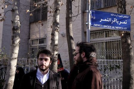 Iranian protesters stand under a street sign with the name of Shi'ite cleric Sheikh Nimr al-Nimr during a demonstration against the execution of Nimr in Saudi Arabia, outside the Saudi Arabian Embassy in Tehran January, 3, 2016. REUTERS/Raheb Homavandi/TIMA