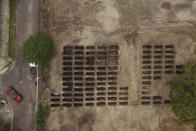 An aerial view of freshly dug graves expand across a section of La Bermeja General Cemetery to meet the demands of the increase in deaths related to the new coronavirus, in San Salvador, El Salvador, Friday, Aug. 7, 2020. For months, the strictest measures confronting the COVID-19 pandemic in Latin America seemed to keep infections in check in El Salvador, but a gradual reopening combined with a political stalemate has seen infections increase nearly fourfold. (AP Photo/Salvador Melendez)