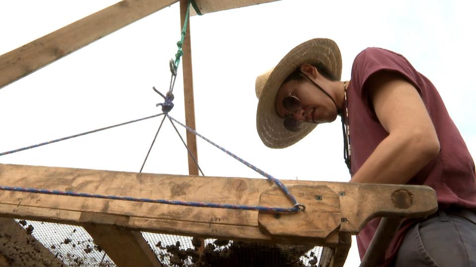 Taryn Healy Crowchief sifts through material at the site on Nose Hill Park in Calgary.