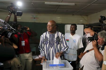 Presidential candidate Roch Marc Kabore (c) votes during the presidential and legislative election at a polling station in Ouagadougou, Burkina Faso, November 29, 2015. REUTERS/Joe Penney