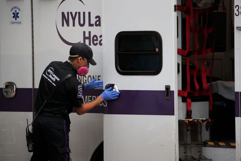Paramedic cleans ambulance outside Maimonides Medical Center during outbreak of coronavirus disease (COVID-19) in Brooklyn New York