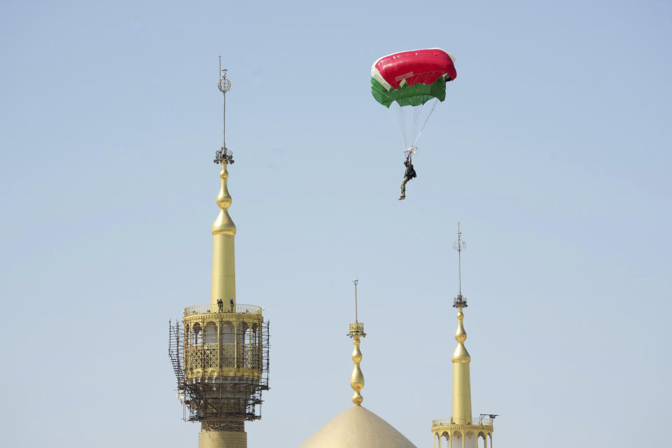 A paratrooper flies down over the mausoleum of the late revolutionary founder Ayatollah Khomeini during Iranian Army Day parade just outside Tehran, Iran, Tuesday, April 18, 2023. Iran's President Ebrahim Raisi on Tuesday reiterated threats against Israel while marking the country's annual Army Day, though he stayed away from criticizing Saudi Arabia as Tehran seeks a détente with the kingdom. (AP Photo/Vahid Salemi)