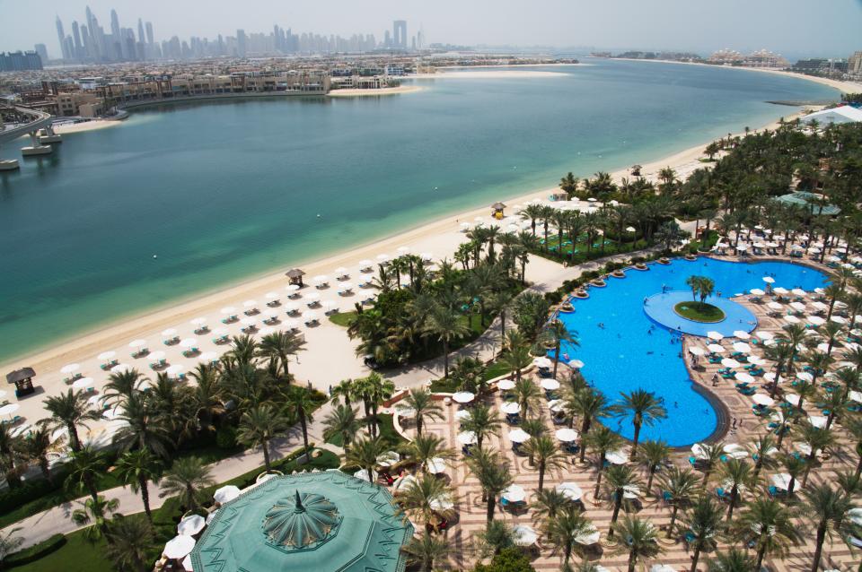 FILE - The pool and beach of the Atlantis Hotel is seen with the skyline of the Dubai Marina visible in the distance in Dubai, United Arab Emirates, July 14, 2020. The Middle East is the most water-scarce region in the world, but participants at an upcoming climate summit in Dubai will be ensconced in a resort with one of the world’s largest water parks, complete with artificial lagoons, encounters with dolphins and a mesmerizing aquarium with sharks, sting rays and schools of fish. (AP Photo/Jon Gambrell, File)