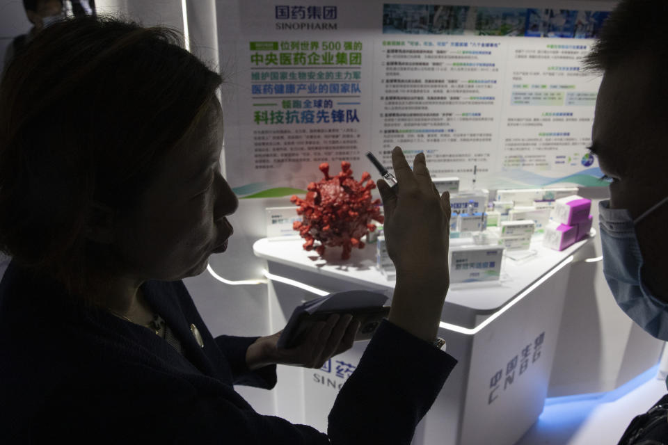 A promoter talks about the COVID-19 vaccine produced by Sinopharm subsidiary CNBG during a trade fair in Beijing on Sunday, Sept. 6, 2020. The Chinese drugmaker said Wednesday, Dec. 30, 2020 its coronavirus vaccine was found to be 79.3% effective at preventing infection in preliminary data from the final round of testing, moving Beijing closer to possibly being able to fulfill its pledge to supply other developing countries.(AP Photo/Ng Han Guan)